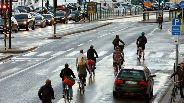 Människor cyklar vid Skeppsbron i Stockholm.