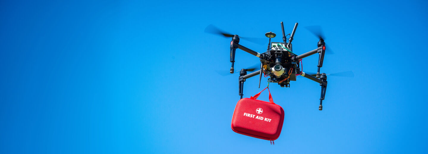 A drone in the air carrying a first aid kit