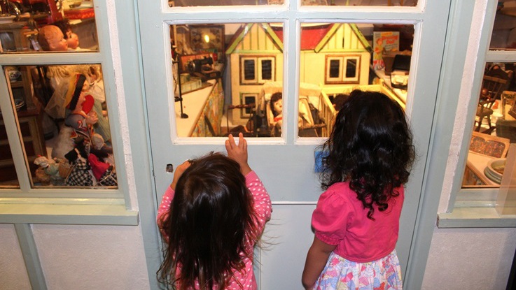 Barn på museum tittar på ett dockhus