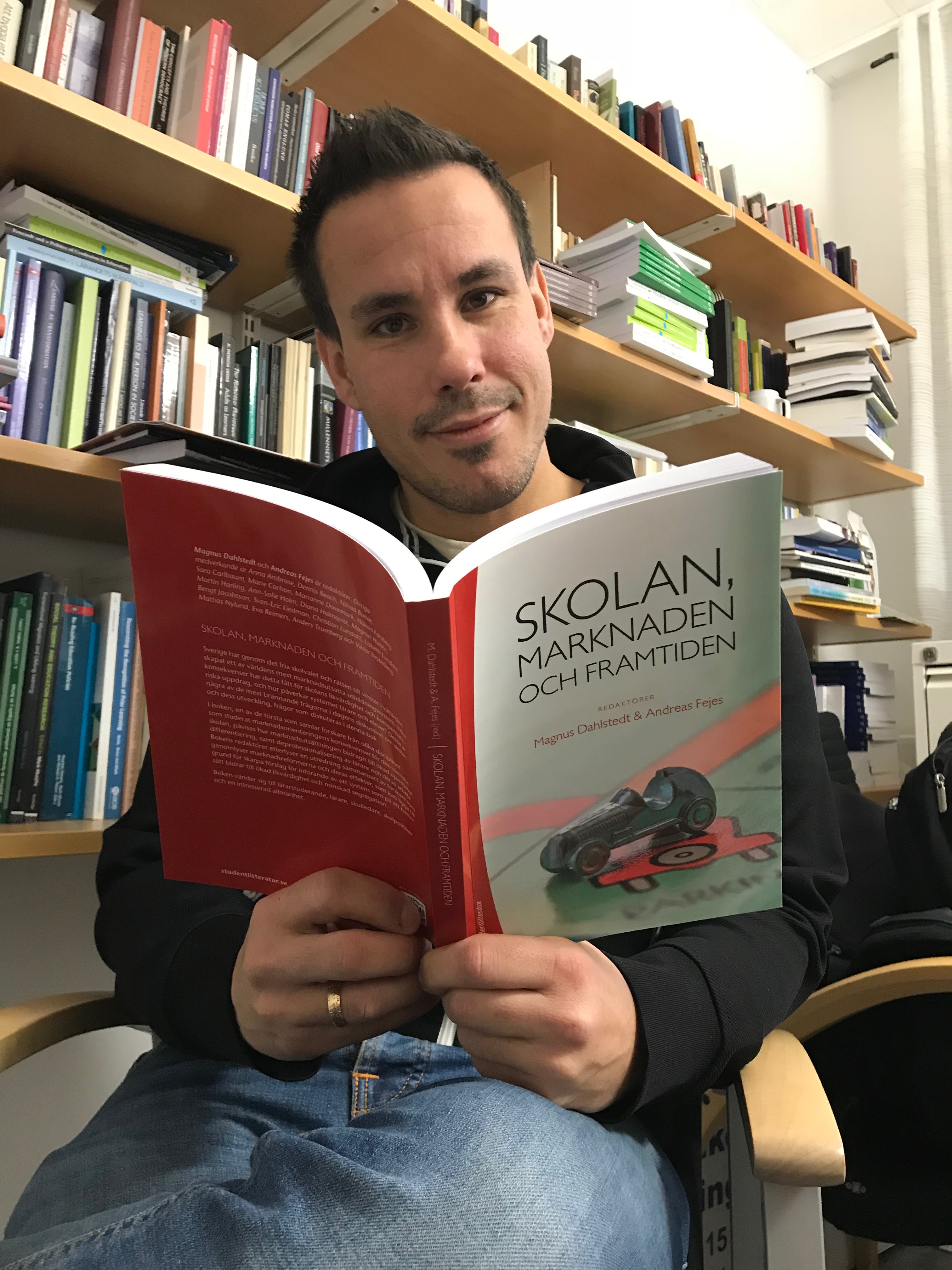 Andreas Fejes visar upp sin bok Skolan, marknaden och framtiden.