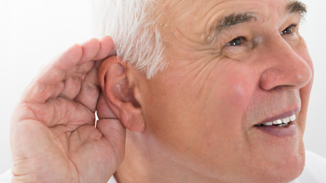 Äldre man håller handen vid örat för att höra bättre.