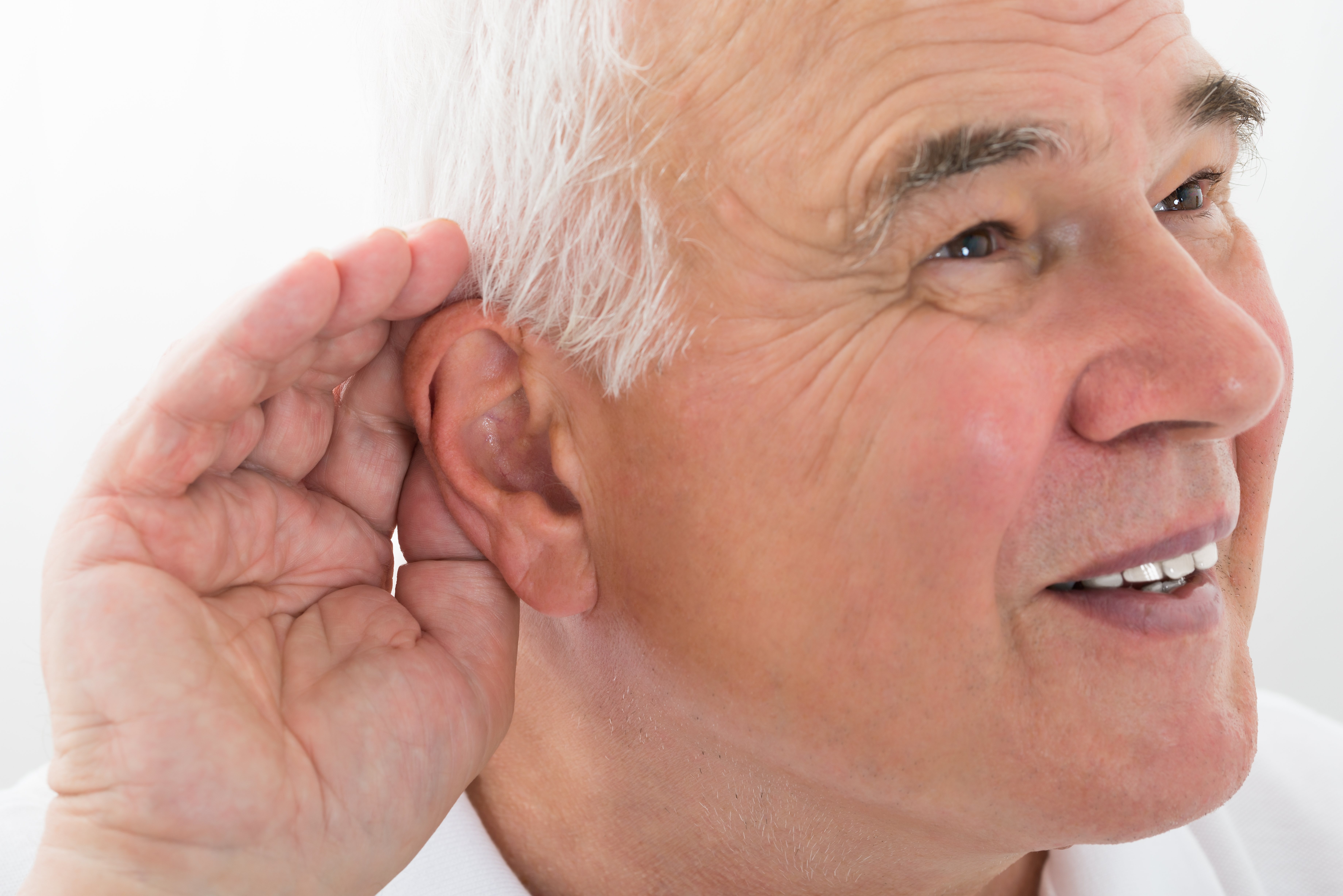 Äldre man håller handen vid örat för att höra bättre.