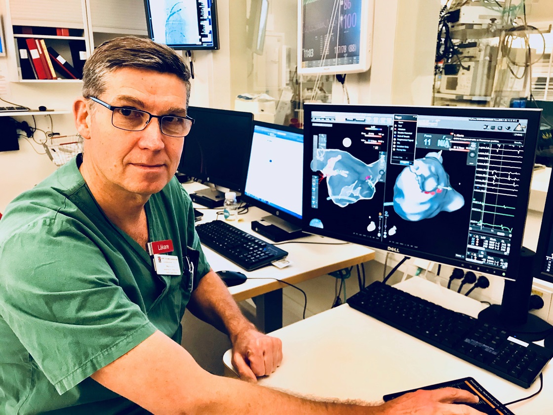 Magnus Janzon, verksamhetschef Kardiologiska kliniken US Linköping, sitter framför en skärm som visar hjärtfrekvens.