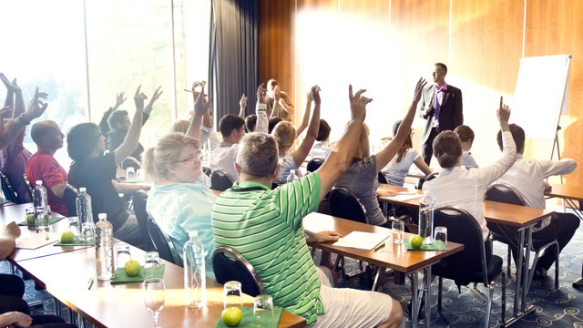 People on motivational seminar. With hands in the air, thumbs up.