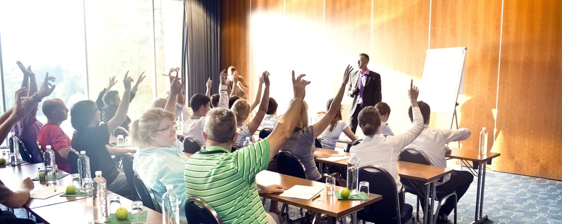 People on motivational seminar. With hands in the air, thumbs up.
