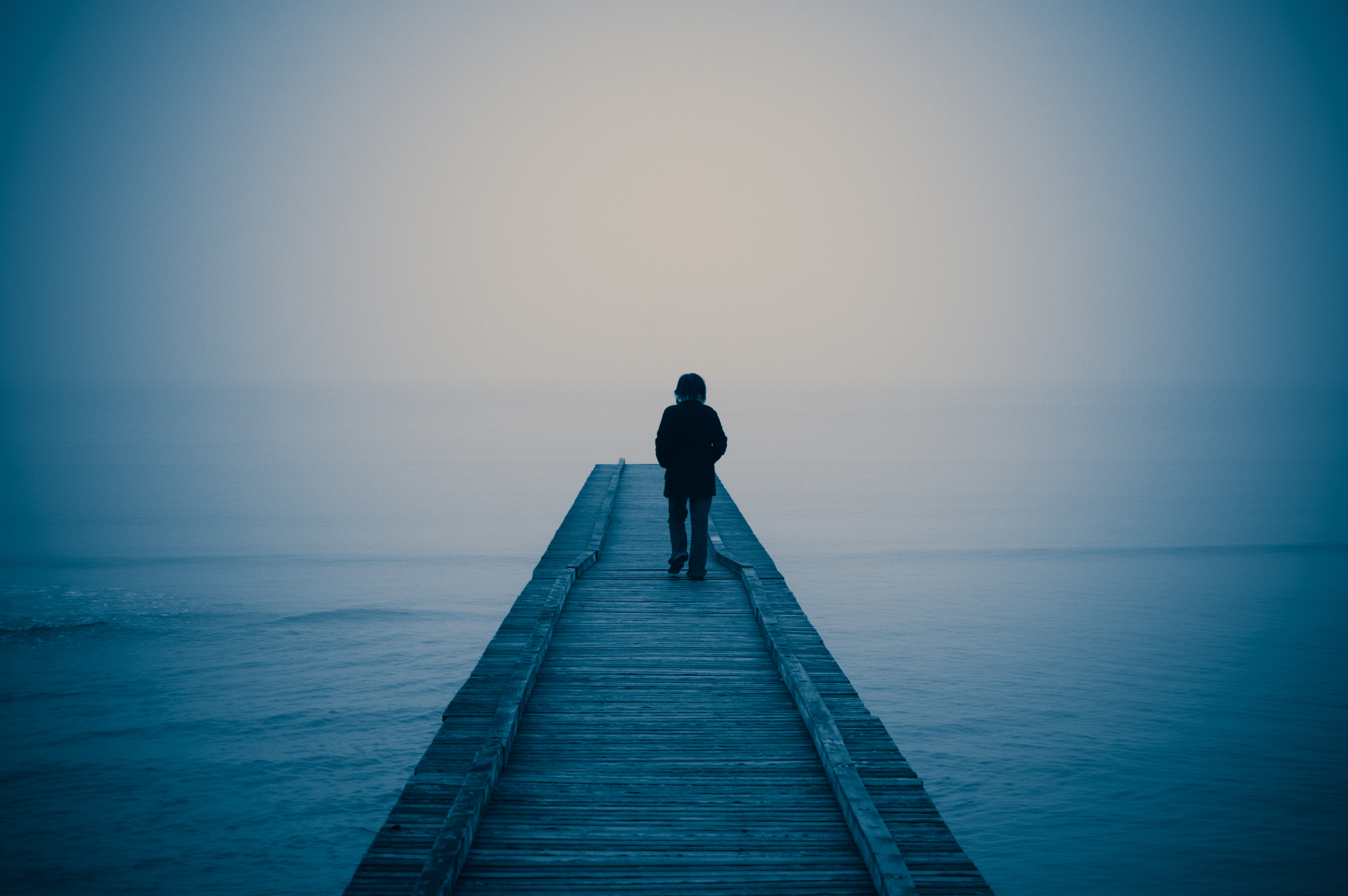 A lonely person is walking out on a bridge