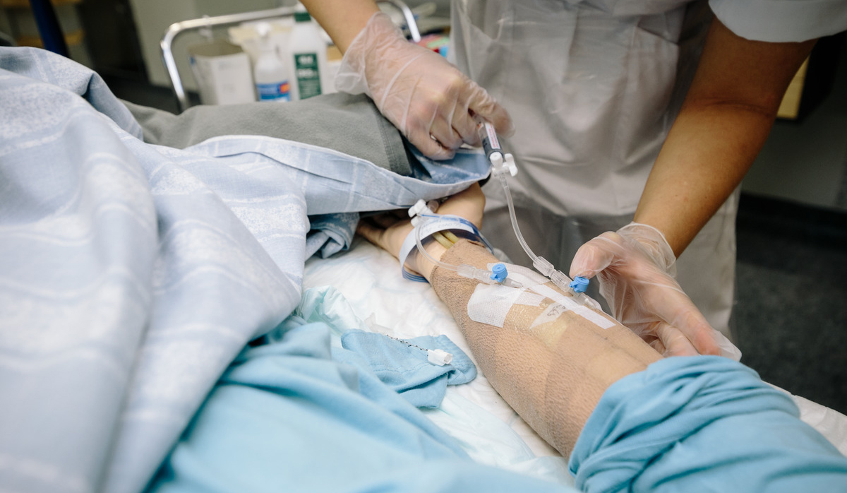 En sjuksköterska jobbar med en kateter på en patient