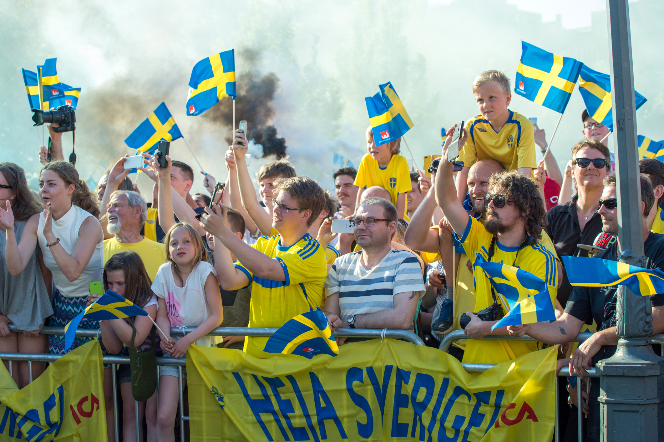 Svenska fotbollssupportrar viftar flaggor