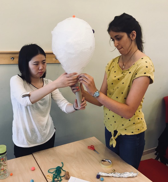 Two students are building a balloonlike prototype