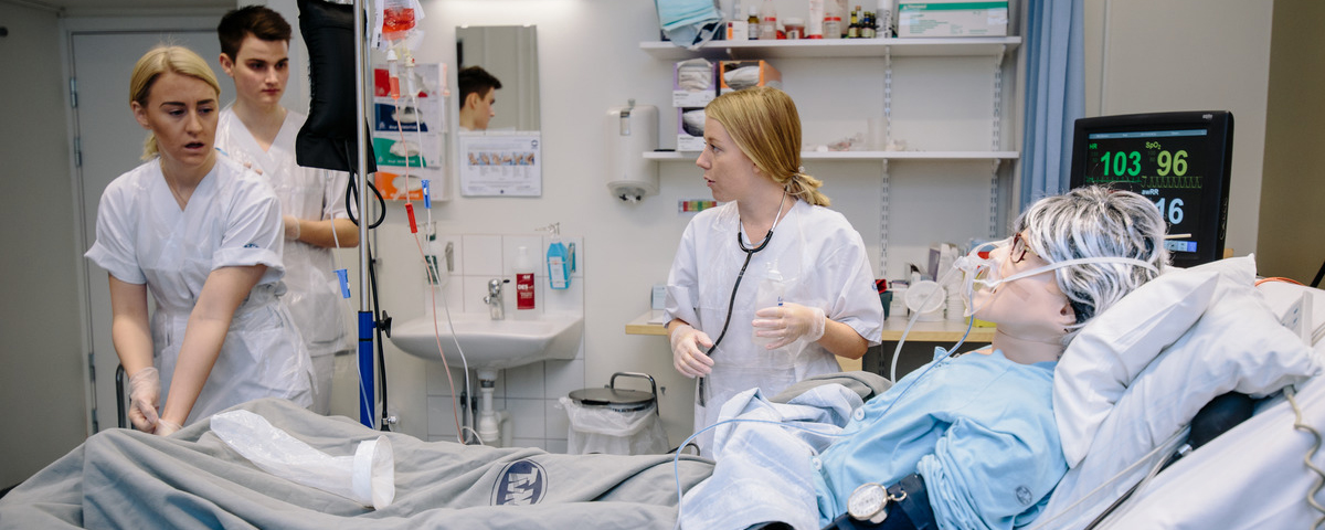 Medicin- och vårdstudenter som övar tillsammans med en simuleringsdocka.