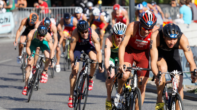 Large group of muscular cycling triathlon competitors 