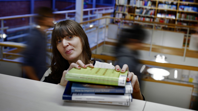Ung kvinna i bibliotek