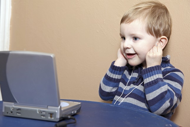 Barn använder dator och lyssnar i hörlurar