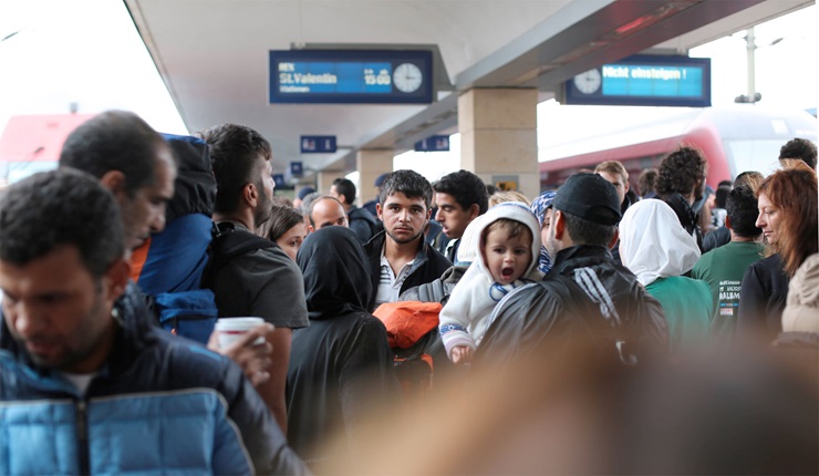 Flyktingar på en tågstation i Europa. 