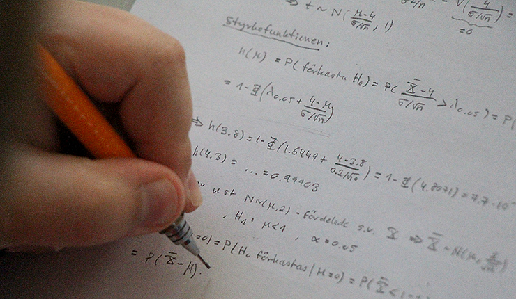 Olle Abrahamsson löser matteproblem. Bara hand, penna och uträkning syns.