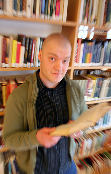 Jim Blomqvist med bok i biblioteket