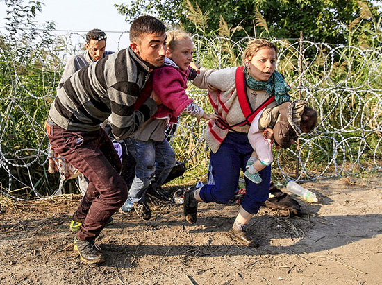 Flyktingar genom taggtråd