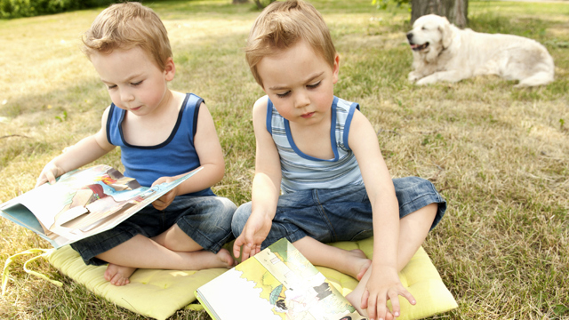 Små tvillingpojkar läser böcker