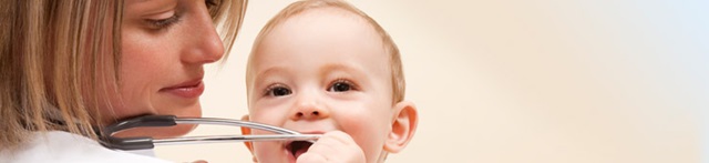 Genrebiild, litet barn som undersöker ett stetoskop med munnen
