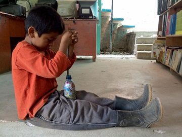 Pojke hjälper till att fylla flaskor med skräp inför ett skolbygge i Guatemala.