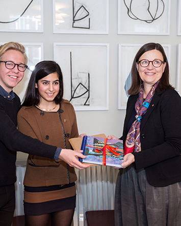 Diana Saleh överlämnar bok till ministern. Foto Nils Larsson
