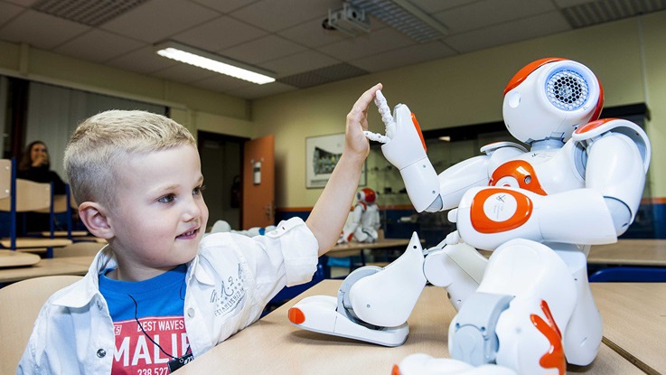 Autistiskt barn gör highfive med robot. Projektet DREAM