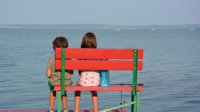 Barn som sitter på en bänk