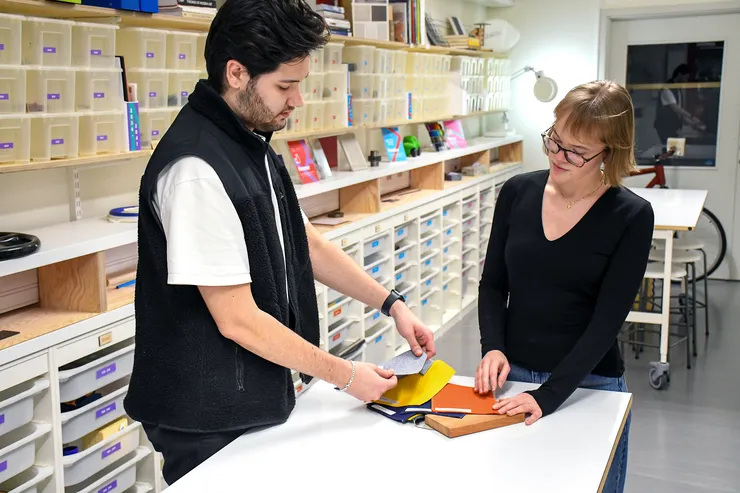 Jonatan Forslund and Emma Lundberg are standing at a table looking at material samples.