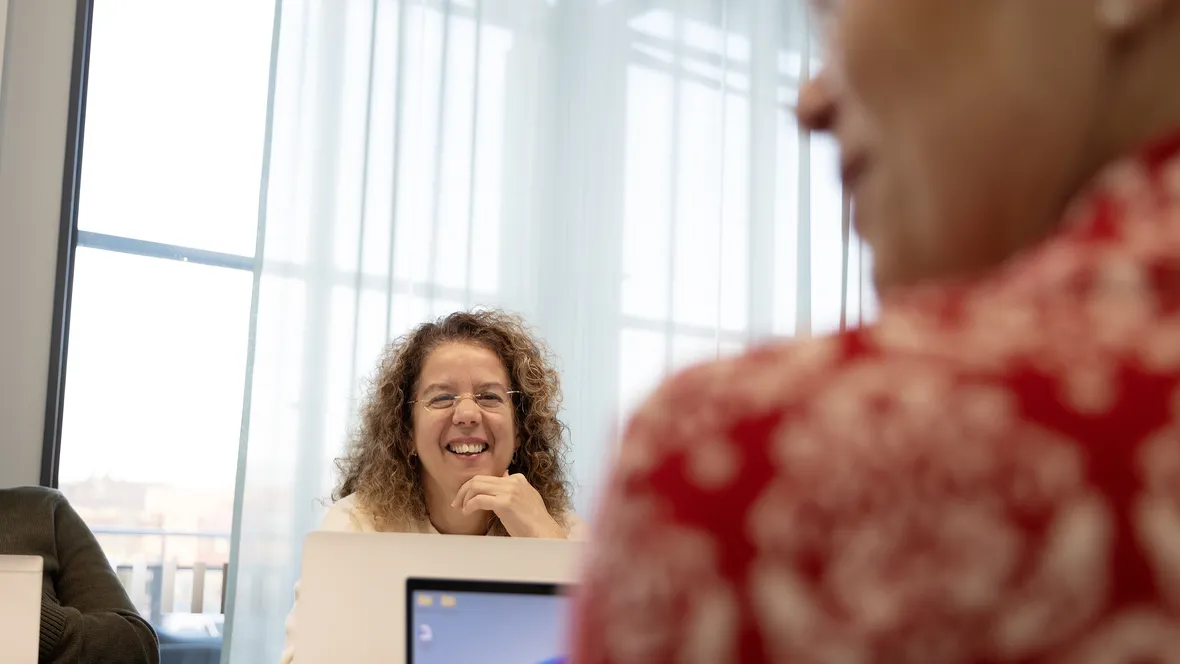 Leende kvinna i ett arbetsmöte