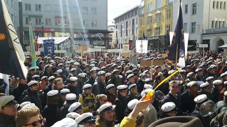 A large group of people wearing white student hats.