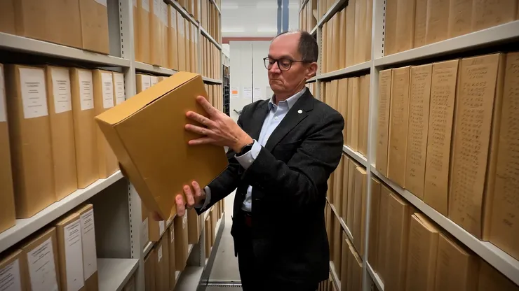 A man taking down a file from a shelf