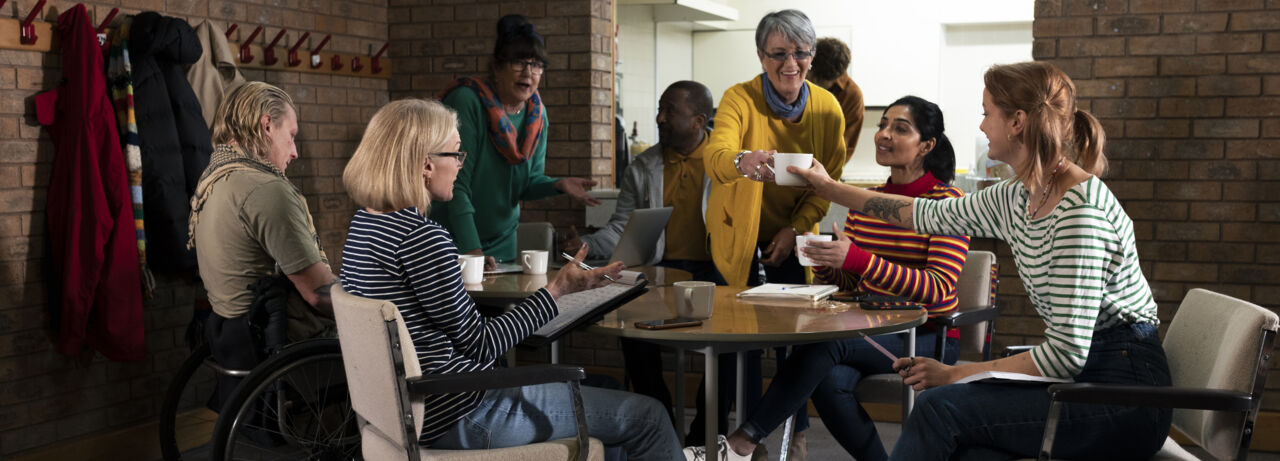 Group of peopple sitting around a table and talks.