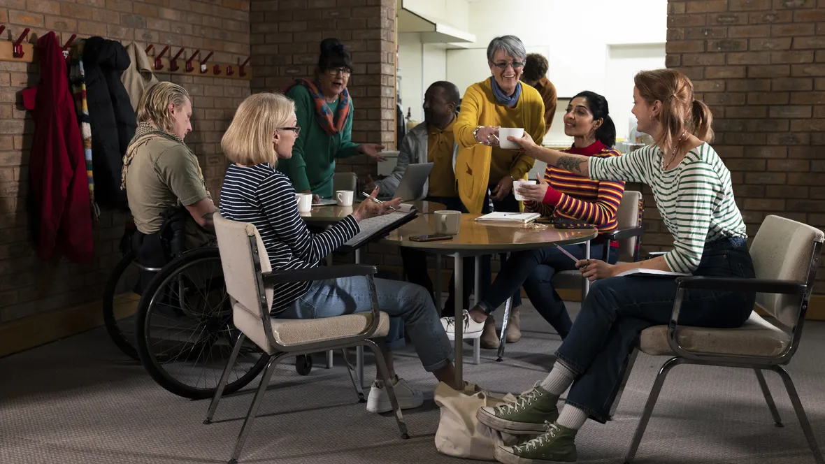 Grupp människor som sitter runt ett bord och pratar.