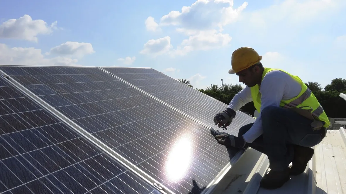 A person on a roof with solar cells