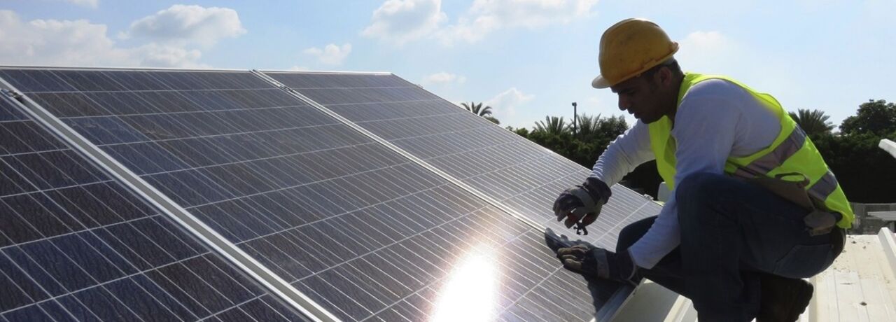 A person on a roof with solar cells