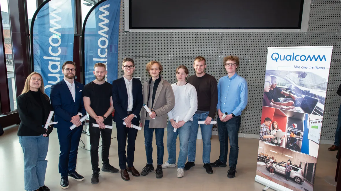 Unga människor med diplom, roll-up och beachflaggor med texten Qualcomm