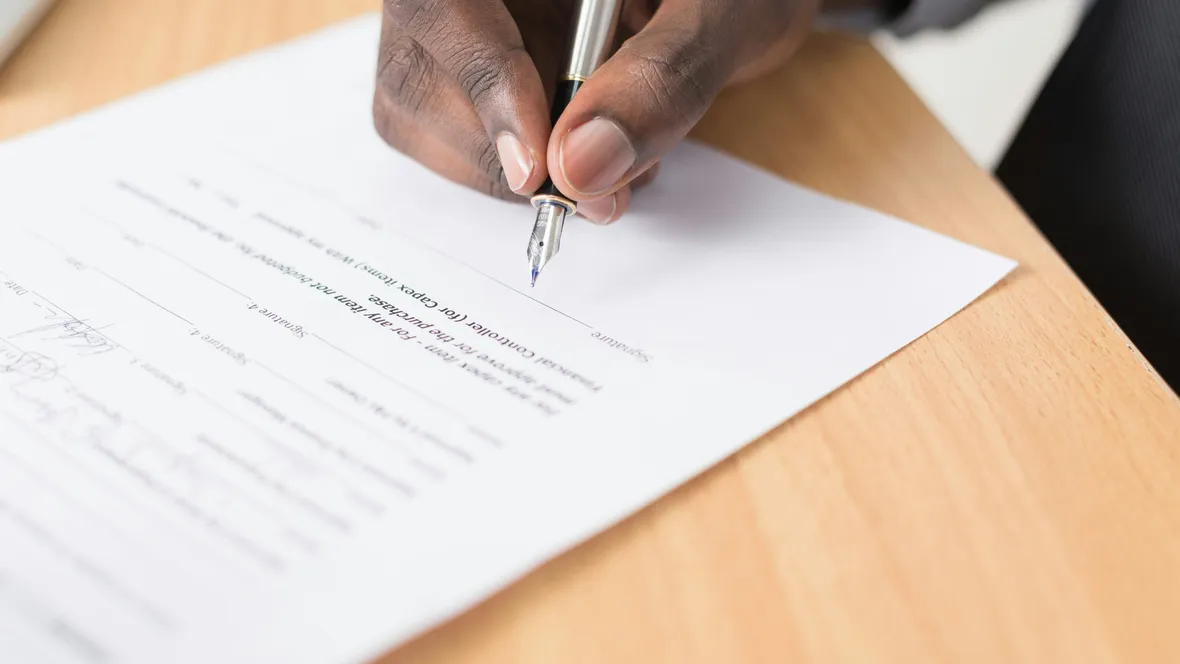 Close-up of a hand signing a document