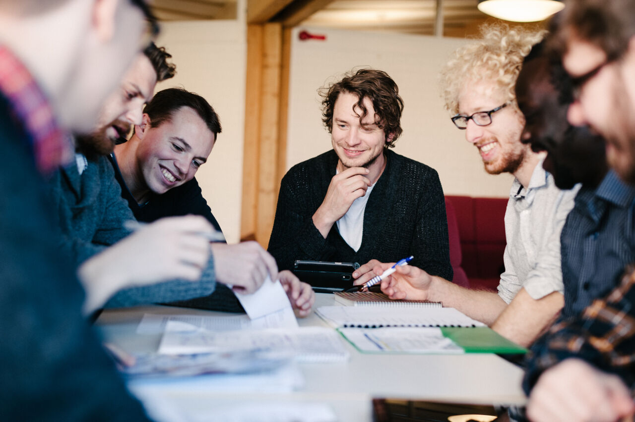 En grupp människor arbetar runt ett bord