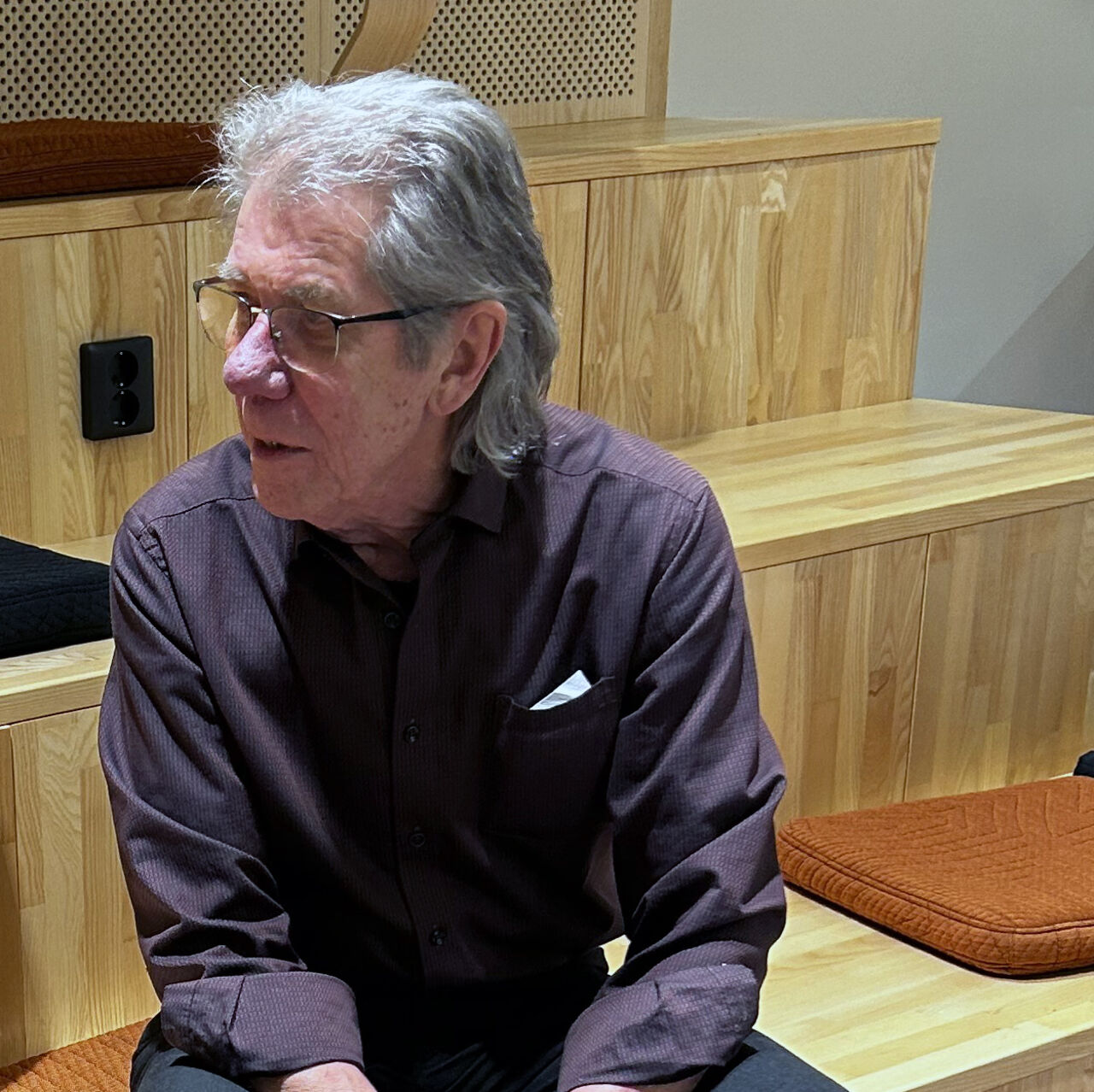 en man sitter på en bänk inomhus