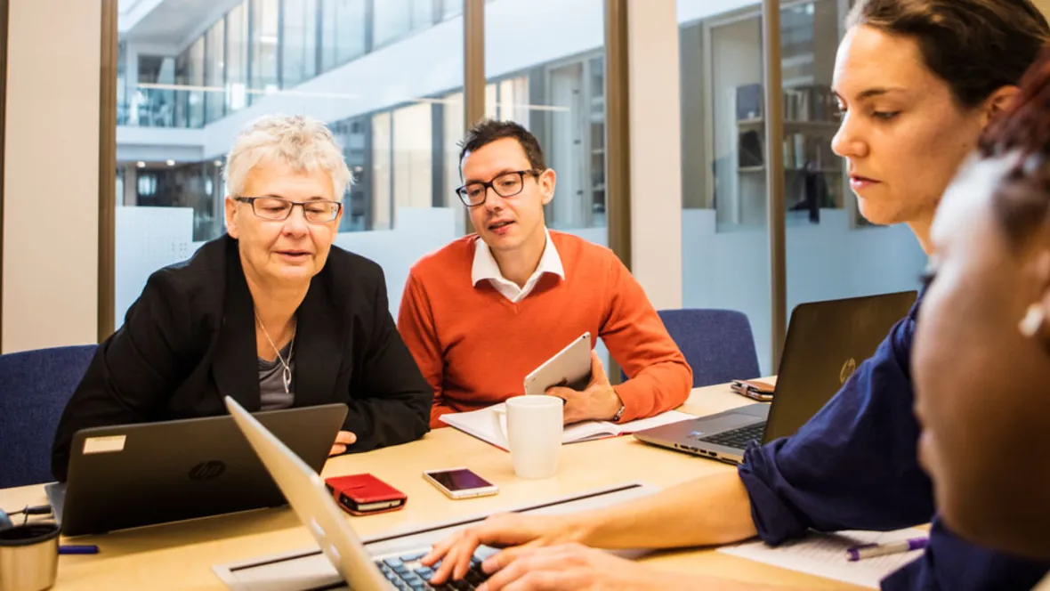 A group of people sitting at a table discussing.