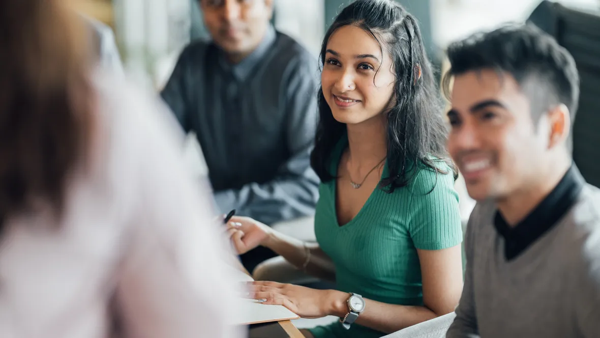 En grupp människor lyssnar på när en person talar.
