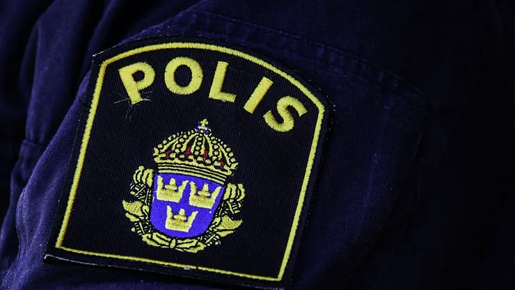 Tygmärke med texten polis.