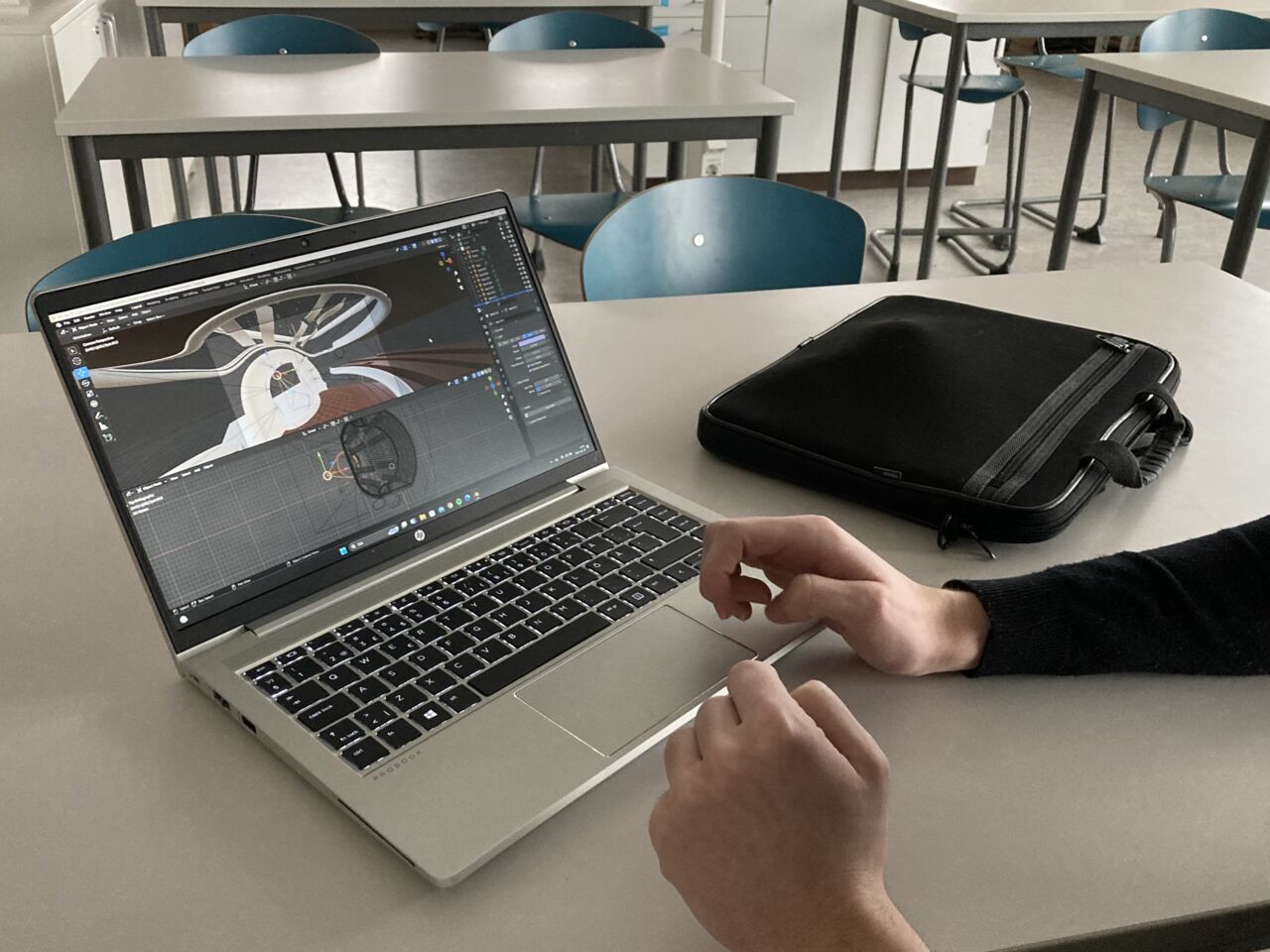 Händer och en dator som visar arkitekturarbete.