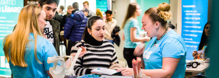 Kvinnlig LiU-student pratar med besökare på mässa