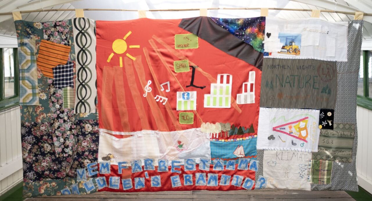 En tygbanderoll i olika färger som hänger i ett tak