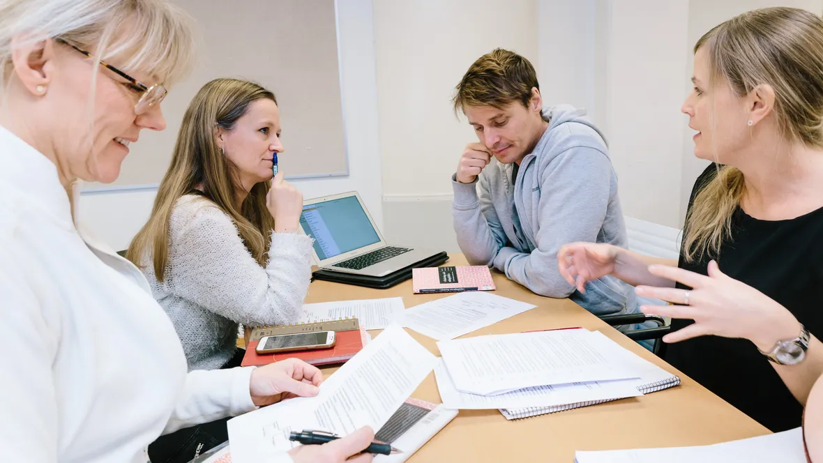 Tre kvinnor och en man kring ett bord