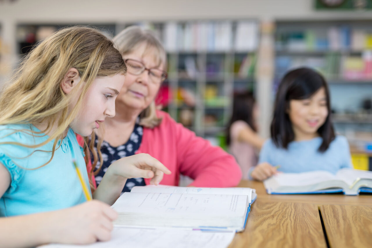 Lärare hjälper barn i ett klassrum.