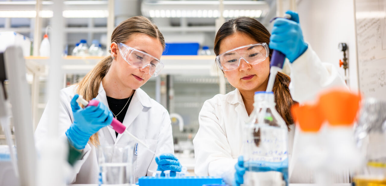 Två studenter labbar.