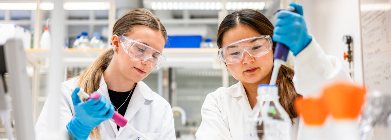 Två studenter labbar.