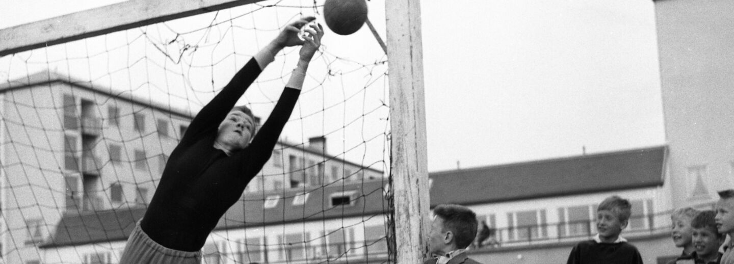 Svartvit bild pojkar som spelar fotboll.